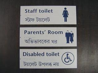 Two languages, Braille and symbols make this sign especially useful. Braille and symbols on signs for a door.