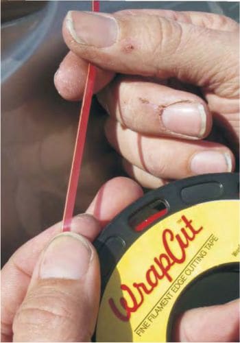 wrapcut adhesive tape held to demonstrate exceptionally fine filament