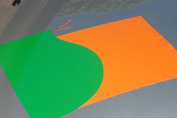 The filament has been pulled out and the overlapping green vinyl has been removed. This leaves the carrier component of the WrapCut tape still to be removed as well as some orange vinyl under the green. Wrapcut tape with two layers of vinyl added over the top ready for the wrapcut tape to be pulled.
