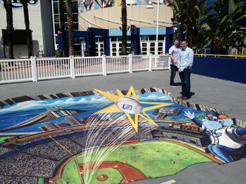 Two men looking at an Alumigraphics surface graphic on the ground