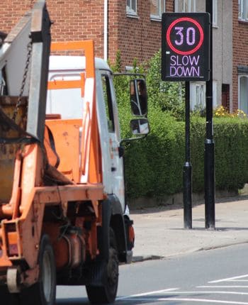 Vehicle activated speed sign on a busy road