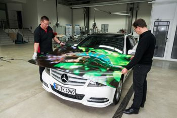 Two men wrapping a car