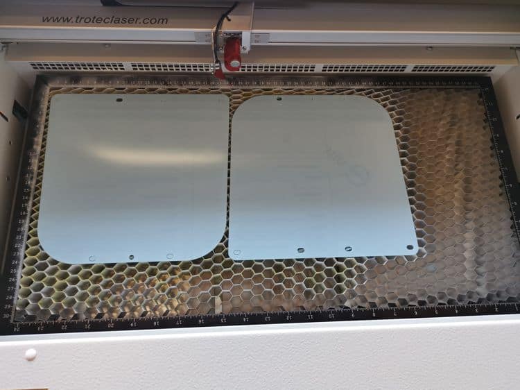 Component of face shield still on the laser cutting machine.