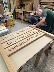 3 Robert working on a large timber sign The heart in timber sign making